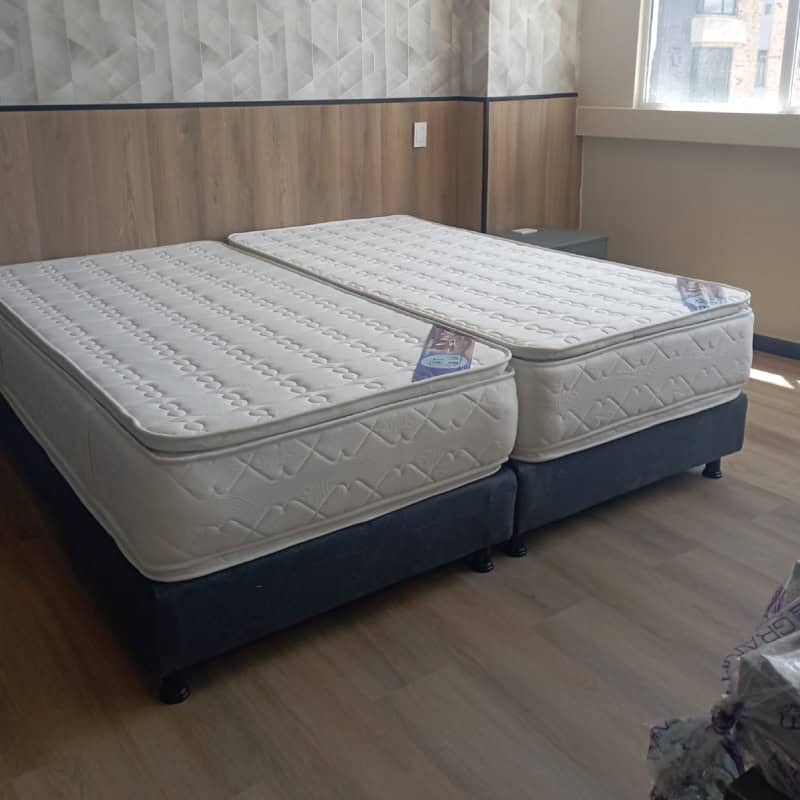 Cama doble con colchones en habitación de hospital, ideal para atención médica y comodidad del pacie.
