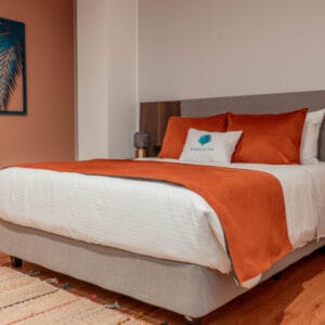 Ropa de cama de microfibra en tonos naranjas y blancos, ideal para hoteles y hospitales, con forro y.